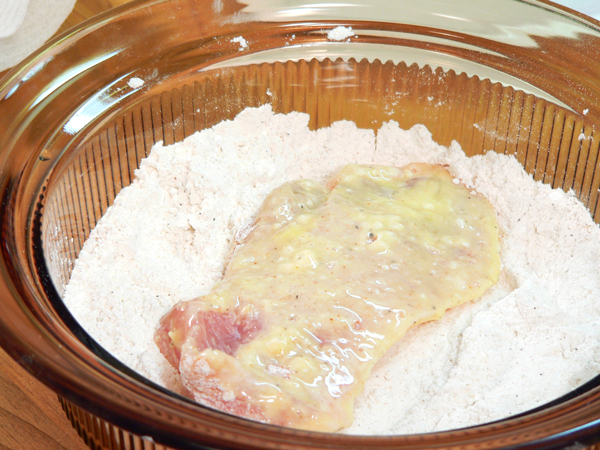 22_Pork-Chops_flour-again Place the chop back in the flour breader mixture once again.