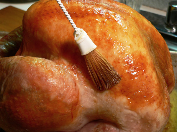 Roast Turkey, baste with pan juices.